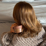 Dream Crème™ Hydrating Hair Mask in Toasted Sugar™ model holding Dream Crème in Toasted Sugar tub next to hair