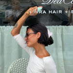 Aura Hair + Body Mist™ in Mochi Milk model spraying aura mist in hair
