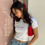 EJ Lady Baby Tee model standing while wearing EJ Lady Baby Tee and bow barrette