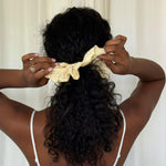 Eyelet Scrunchie in Daylily model adjusting Eyelet Scrunchie in Daylily in hair