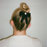 Mini Iconic Velvet Bow Barrette in Noir model wearing Mini Iconic Velvet Bow Barrette in Noir in hair