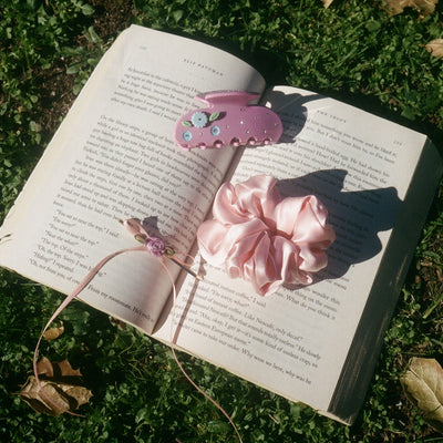 Sweetheart Clip in Mauve Bloom with scrunchie on book