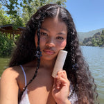 Baby Super Bloom Clip Set in Blackberry model holding aura hair mist against cheek while wearing Baby Super Bloom Clip Set in Blackberry in hair