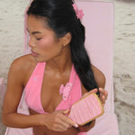 Bamboo Paddle Brush in Lychee Baby model wearing hair pin brushes hair with Bamboo Paddle Brush in Lychee Baby