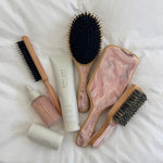 Bamboo Paddle Brush in Pink Chantilly Bamboo Paddle Brush in Pink Chantilly with assorted styling tools and hair care