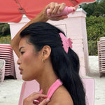 Big Effing Clip in Lychee Hibiscus model spraying aura hair + body mist in lychee baby while wearing Big Effing Clip in Lychee Hibiscus in hair
