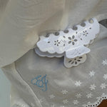 Big Effing Clip in Blanc Fleur Eyelet Big Effing Clip in Blanc Fleur Eyelet attached to fabric with embroidered EJ in blue