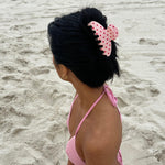 Big Effing Clip in Blush Polka Dot model wearing Big Effing Clip in Blush Polka Dot while sitting on beach in pink bikini