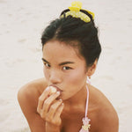Big Effing Clip in Citrus Polka Dot model eating lychee while wearing Big Effing Clip in Citrus Polka Dot in hair