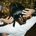 Iconic Velvet Bow Barrette in Noir model with hands above head wearing Bow Barrette in Iconic Velvet