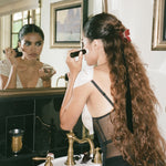 Bow Clip in Poinsettia model looking into mirror with Bow Clip in Poinsettia in hair