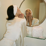 Cloud Headband in Sugar Blossom model looking in mirror with Cloud Headband in Sugar Blossom holding back hair
