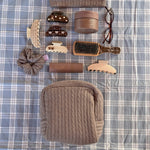 Cozy Pouch in Cookie Crumbs Knit Cozy Pouch in Cookie Crumbs Knit next to assorted hair care, accessories, mini boar brush, and glasses