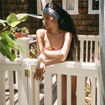 Infinity Headband in Navy Gingham model leaning over door while wearing Infinity Headband in Navy Gingham in hair