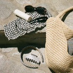 Hair Pin in Noir assorted hair care and accessories with a purse and sunglasses on stone steps