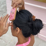 Hair Pin in Tortoise Hibiscus model brushing hair with mini boar brush while wearing Hair Pin in Tortoise Hibiscus