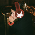 Heartbreaker Clip in Gold Tiara model leaning on present while wearing Sugar Muffs with Heartbreaker Clip in Gold Tiara in hair