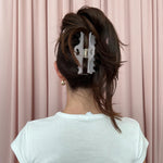 Heartbreaker Clip in Pink Smoke model standing in front of pink curtain wearing Heartbreaker Clip in Pink Smoke in hair