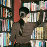 Heart Hair Tie in Gold Tiara model looking at books with Heart Hair Tie in Gold Tiara in hair