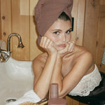 Heavenly Hair Towel in Toasted Sugar olivia jade wearing Heavenly Hair Towel in Toasted Sugar with assorted hair care and accessories on counter