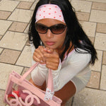 Infinity Headband in Berry Dot model holding purse while wearing sunglasses and Infinity Headband in Berry Dot