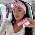 Infinity Headband in Berry Dot model holding aura hair + body mist in lychee baby and angelstick while wearing Infinity Headband in Berry Dot in hair