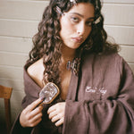 Mini Bamboo Paddle Brush in Toasted Sugar model wearing popstar clips, emi jay robe, and sweetheart clip brushing hair with Mini Bamboo Paddle Brush in Toasted Sugar