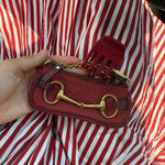 Petite Clip in Cherry Kiss model holding clutch with Petite Clip in Cherry Kiss attached