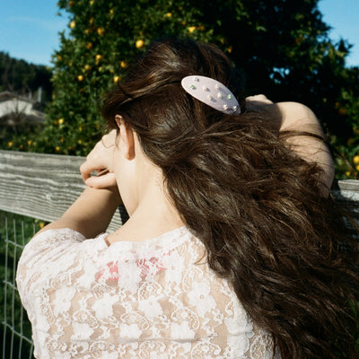 model leaning on fence with Ponytail Barrette in Full Bloom in hair