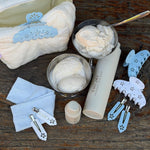 Popstar Clips in Blue Mist Eyelet Popstar Clips in Blue Mist Eyelet on table with ice cream in dish, heavenly hair milk, pouch, and hair accessories