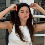 Ruffle Headband in Noir model adjusting Ruffle Headband in Noir in hair