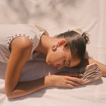 Big Effing Clip in Buttercream model holding a bamboo paddle brush in zebra while showing how to wear a Big Effing Clip in Buttercream in hair