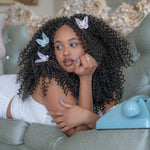 Butterfly Barrette Set in Dawn model laying next to phone with Butterfly Barrette Set in Dawn + Dusk in hair