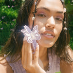 Mariposa Clip in Lilac Sunset model looking at camera with Mariposa Clip in Lilac Sunset in hand