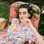 Baby Daisy Clip Set in Lychee model sitting with Baby Daisy Clip Set in Lychee + Jade + Aqua in hair