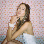 Baby Heart Clip Set in Sweet model with Baby Heart Clip Set in Sweet + Tart in hair and hand on chin