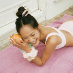 Big Effing Clip in Lilac Buttercream model laughing while holding an orange and wearing a Big Effing Clip in Lilac Buttercream