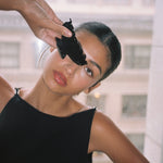 Big Effing Clip in Noir model holding Big Effing Clip in Noir in front of eye