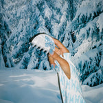 Luna Clip in Snow Baby holding a Luna Clip in Snow Baby in front of snow covered trees