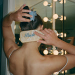 Mariposa Clip in Sweet Cloud model wearing Mariposa Clip in Sweet Cloud while brushing hair with Bamboo Brush in Bride