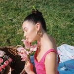 model holding flowwers with Pin Up Sticks in Green Daydream in hair