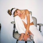 Pointelle Headband in Powder model sitting with Pointelle Headband in Powder in hair