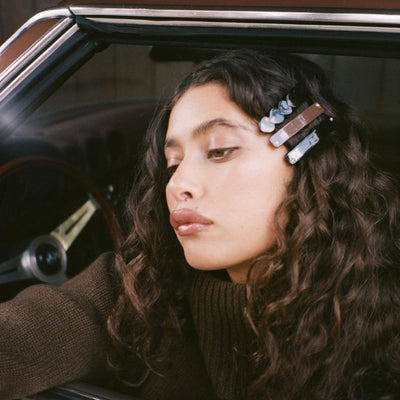 Model leaning out of window of car while wearing Barrette Set in Bear Hug in hair.