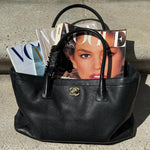 bag with multiple copies of vogue magazine and big effing clip in vogue attached to handle 