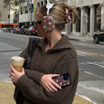 model wearing Big Effing Clip in Brown Floral while holding phone with WIldflower phone case