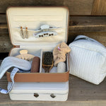 Cozy Pouch in Dream Cloud Knit next to vanity cases with assorted emi jay hair care and accessories