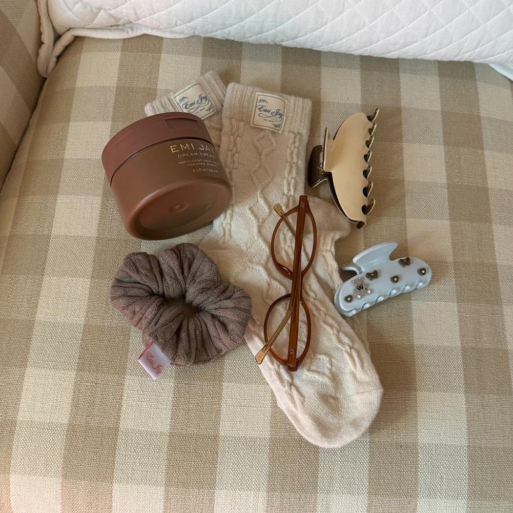 assorted emi jay hair care, accessories, and socks with glasses on chair
