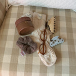 assorted emi jay hair care, accessories, and socks with glasses on chair