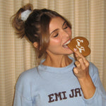 Olivia Jade biting into Emi Jay cookie while wearing Cozy Scrunchie in Dream Cloud Knit in hair