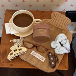 Cozy Scrunchie in Dream Cloud Knit with assorted emi jay hair care, accessories, and coffee